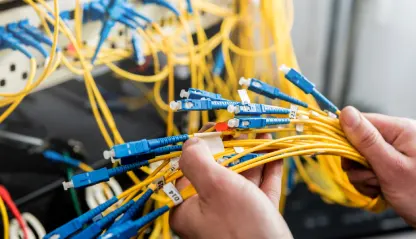 network-engineer-working-server-room-connecting-network-cables-switches-e1760626199512.webp